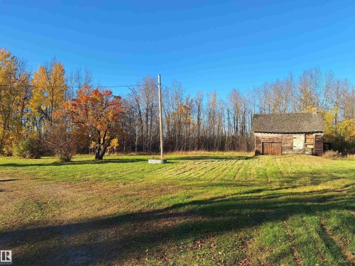 Rustic outbuilding featuring a wood shingle roof and double wood doors - 0326005;1;1 Boyle, Alberta, Boyle, AB - Outdoor With View