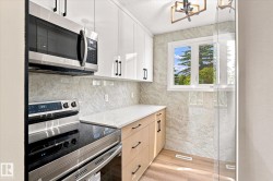 Kitchen featuring stainless steel appliances, light wood-finish cabinetry, white countertops, and a full-height tiled backsplash - 