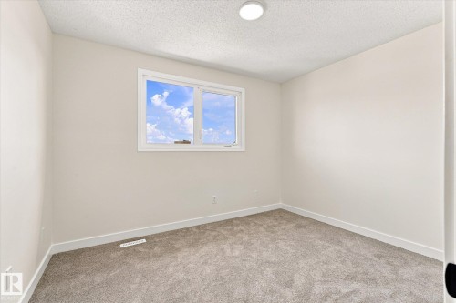 Neutral wall paint, plush carpeting, recessed lighting, and a dual-pane window - 18307 66 Avenue Nw, Edmonton, AB - Indoor Photo Showing Other Room