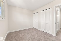 Neutral tone walls, light-colored carpeting, and white bi-fold closet doors - 