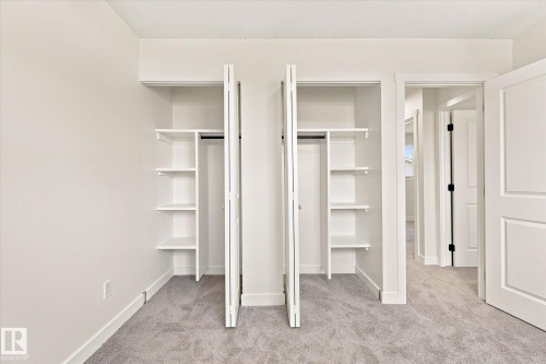 Dual custom built-in closets featuring integrated shelving and hanging rods - 18307 66 Avenue Nw, Edmonton, AB - Indoor Photo Showing Other Room