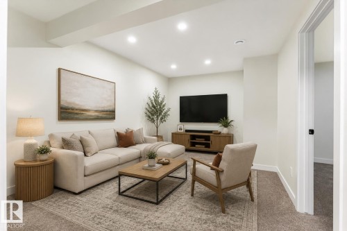 Recessed lighting illuminates the space, featuring a built-in media console and a doorway with a matte black door handle - 18307 66 Avenue Nw, Edmonton, AB - Indoor Photo Showing Other Room
