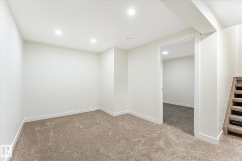 Recessed lighting, neutral wall tones, plush carpet, white trim throughout, and a doorway opening to an additional room - 18307 66 Avenue Nw, Edmonton, AB - Indoor