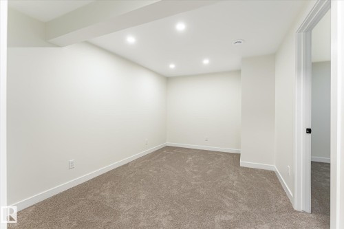 Recessed lighting, neutral wall finishes, plush carpeting, white trim, and a white interior door with black hardware - 18307 66 Avenue Nw, Edmonton, AB - Indoor Photo Showing Other Room