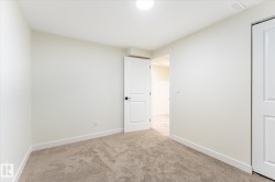 Plush carpeting, white trim, and a white interior door with black hardware - 