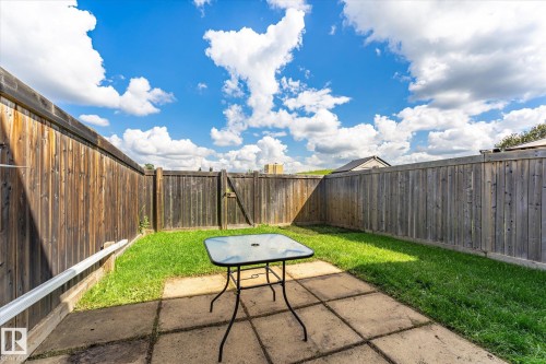 Enclosed backyard featuring wood fencing, a grass lawn, and a paved patio area - 18307 66 Avenue Nw, Edmonton, AB - Outdoor