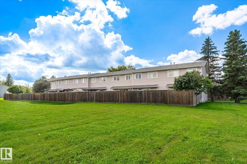 Expansive green space with a wood privacy fence and mature trees - 18307 66 Avenue Nw, Edmonton, AB - Outdoor