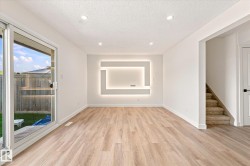 Recessed ceiling lighting, wood-finish flooring, sliding glass door, built-in wall feature with backlighting, and carpeted stairs - 