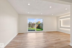 Wood-finish flooring throughout, recessed ceiling lighting, sliding glass door, and integrated wall lighting feature - 