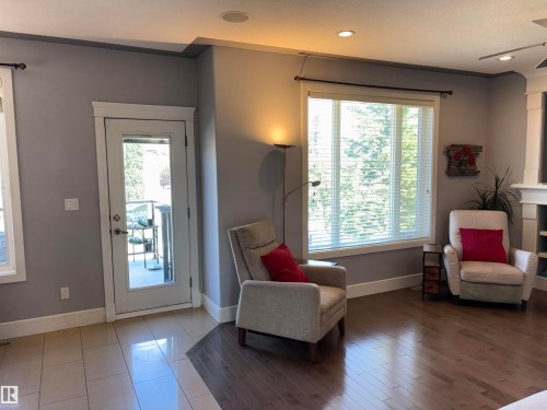 Recessed ceiling lighting, large picture window with blinds, French door, wood-finish flooring, and light-toned tile flooring - 1452 36A Avenue Nw, Edmonton, AB - Indoor Photo Showing Other Room