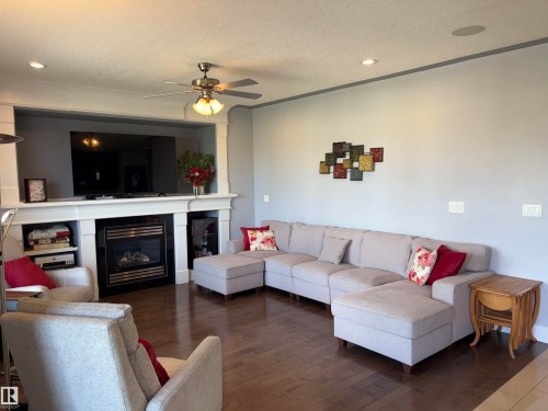 Wood-finish flooring, recessed lighting, ceiling fan, built-in fireplace with mantel, built-in shelving - 1452 36A Avenue Nw, Edmonton, AB - Indoor Photo Showing Living Room With Fireplace