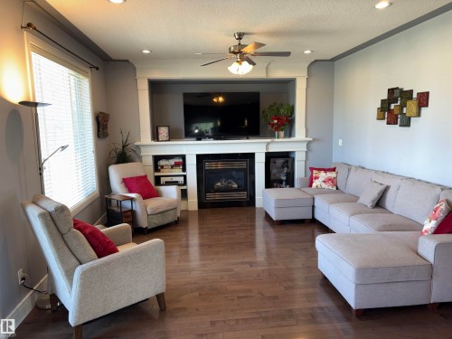 Hardwood flooring, recessed lighting, ceiling fan, white window blinds, and a built-in fireplace with a mantel - 1452 36A Avenue Nw, Edmonton, AB - Indoor Photo Showing Living Room With Fireplace