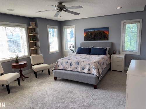 Room featuring neutral gray carpeting and multiple windows with white blinds - 1452 36A Avenue Nw, Edmonton, AB - Indoor Photo Showing Bedroom