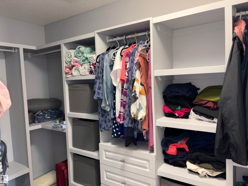 Built-in closet system with shelving, hanging rods, and drawers - 1452 36A Avenue Nw, Edmonton, AB - Indoor With Storage
