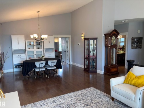 Vaulted ceilings with a suspended light fixture, wood-finish flooring, and built-in cabinetry - 1452 36A Avenue Nw, Edmonton, AB - Indoor Photo Showing Living Room