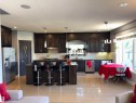 Kitchen featuring dark wood-finish cabinetry, stainless steel appliances, a central island with bar seating, and tile flooring - 1452 36A Avenue Nw, Edmonton, AB  - Indoor Photo Showing Kitchen With Upgraded Kitchen 