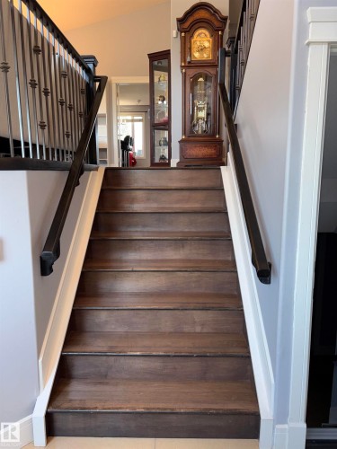 Wood-finish staircase with wrought iron balusters and dark wood handrails - 1452 36A Avenue Nw, Edmonton, AB - Indoor Photo Showing Other Room