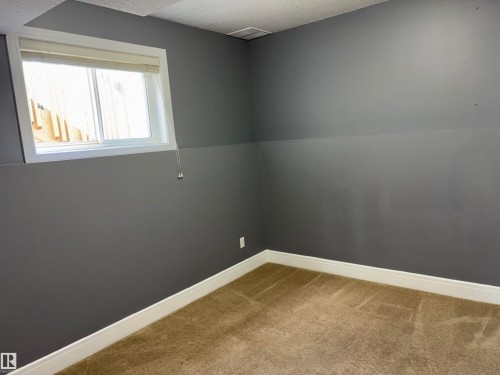 Carpeted flooring, painted walls, white trim, and a window with blinds - 1452 36A Avenue Nw, Edmonton, AB - Indoor Photo Showing Other Room