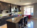 Kitchen featuring dark wood cabinetry, granite countertops, tile backsplash, and stainless steel appliances - 1452 36A Avenue Nw, Edmonton, AB  - Indoor Photo Showing Kitchen With Upgraded Kitchen 