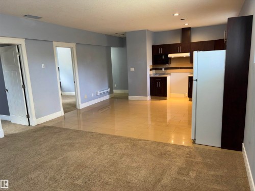 Kitchen featuring dark wood-finish cabinetry, built-in range hood, and recessed lighting - 1452 36A Avenue Nw, Edmonton, AB - Indoor Photo Showing Kitchen