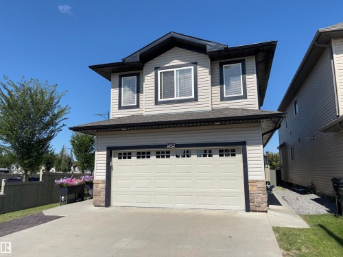 Contemporary exterior with light siding, dark trim, an attached garage, and a concrete driveway - 1452 36A Avenue Nw, Edmonton, AB - Outdoor With Exterior