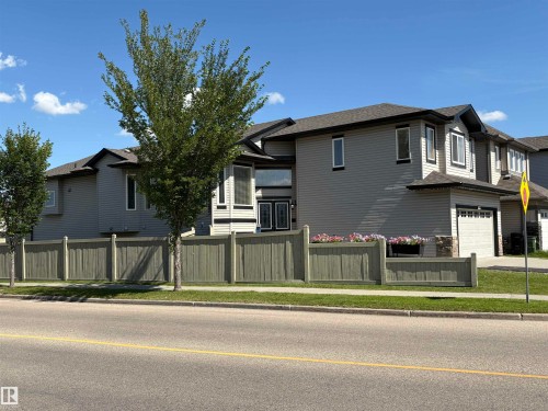 Two-story residence featuring light gray siding, dark trim accents, a single-car garage, and a full privacy fence - 1452 36A Avenue Nw, Edmonton, AB - Outdoor