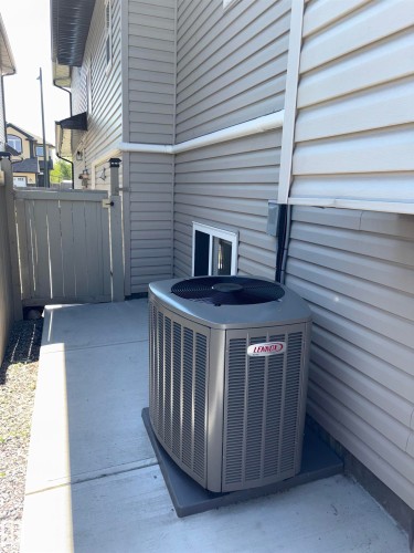 Lennox air conditioning unit on a concrete pad, situated on a concrete patio - 1452 36A Avenue Nw, Edmonton, AB - Outdoor With Exterior