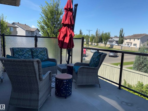 Outdoor balcony with a glass and black metal railing, featuring a concrete surface - 1452 36A Avenue Nw, Edmonton, AB - Outdoor