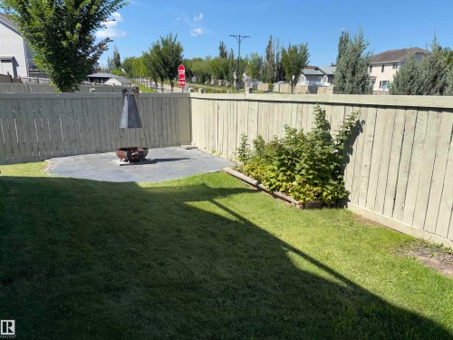 Expansive backyard featuring a manicured lawn, full privacy fencing, and a built-in stone patio - 1452 36A Avenue Nw, Edmonton, AB - Outdoor