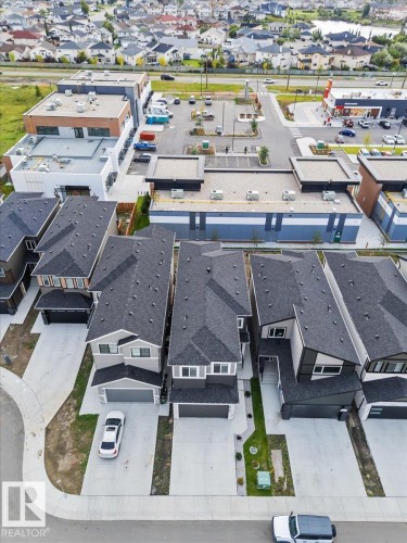 Aerial perspective showcasing multiple residential properties with attached garages and surrounding commercial establishments - 6903 169 Avenue Nw, Edmonton, AB - Outdoor With View