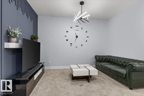 Recessed lighting, wall-mounted shelving, built-in media console, and a contemporary chandelier - 6903 169 Avenue Nw, Edmonton, AB - Indoor