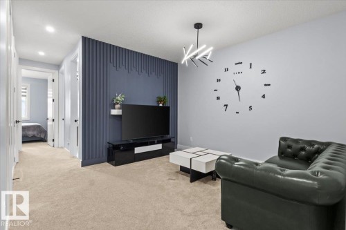 Recessed ceiling lighting, textured accent wall, contemporary pendant light fixture, light neutral-toned carpet, and contrasting interior doors - 6903 169 Avenue Nw, Edmonton, AB - Indoor