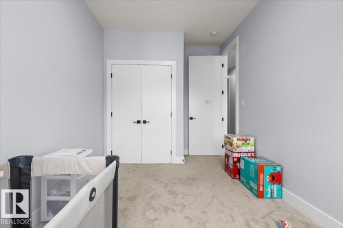 Plush carpeted flooring with light gray walls, featuring a white double-door closet with matte black hardware - 6903 169 Avenue Nw, Edmonton, AB - Indoor