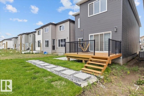 Rear exterior with a wood-finish deck and black metal railing - 6903 169 Avenue Nw, Edmonton, AB - Outdoor With Deck Patio Veranda