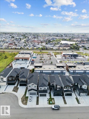 Newly constructed townhome community featuring modern architectural design with clean-lined exteriors, attached garages, and organized street frontage - 6903 169 Avenue Nw, Edmonton, AB - Outdoor With View