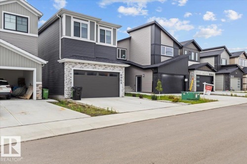 Modern two-story exterior featuring a stone facade and dark horizontal siding - 6903 169 Avenue Nw, Edmonton, AB - Outdoor With Facade