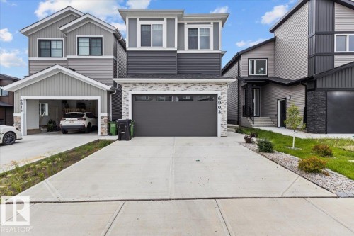 Two-story facade with stone veneer accents, an attached garage, and a concrete driveway - 6903 169 Avenue Nw, Edmonton, AB - Outdoor With Facade
