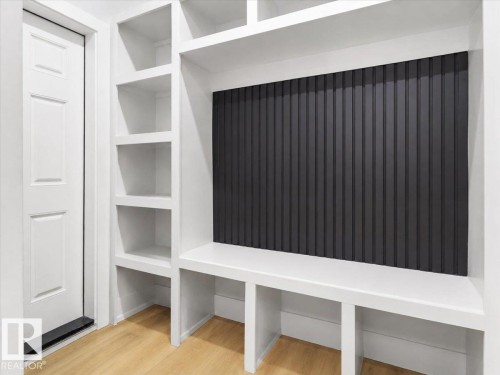 Built-in shelving, integrated bench seating, and light wood-finish flooring - 6903 169 Avenue Nw, Edmonton, AB - Indoor Photo Showing Other Room