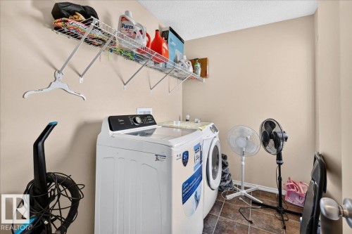 Laundry area with tile flooring and a built-in wire shelving unit - 1529 26 Ave Nw Nw, Edmonton, AB - Indoor Photo Showing Laundry Room
