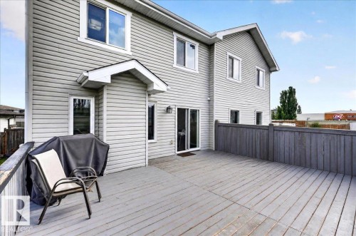 Expansive wood-finish deck with privacy fencing, siding exterior, and sliding glass door access - 1529 26 Ave Nw Nw, Edmonton, AB - Outdoor With Deck Patio Veranda With Exterior