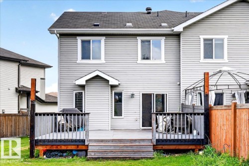 Rear exterior featuring light-colored siding, a multi-level wooden deck, and a privacy fence - 1529 26 Ave Nw Nw, Edmonton, AB - Outdoor With Deck Patio Veranda With Exterior