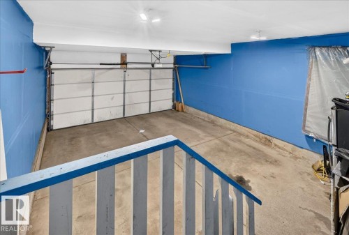 Enclosed garage space with a concrete floor, equipped with overhead lighting and a white paneled garage door - 1529 26 Ave Nw Nw, Edmonton, AB - Indoor Photo Showing Garage