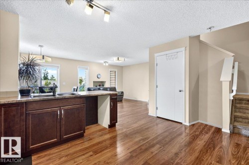 Open-concept layout with wood-finish flooring - 1529 26 Ave Nw Nw, Edmonton, AB - Indoor Photo Showing Kitchen With Double Sink