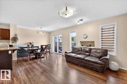 Wood-finish flooring throughout, multiple windows, built-in wall niche, recessed lighting, and a sliding glass door - 1529 26 Ave Nw Nw, Edmonton, AB - Indoor