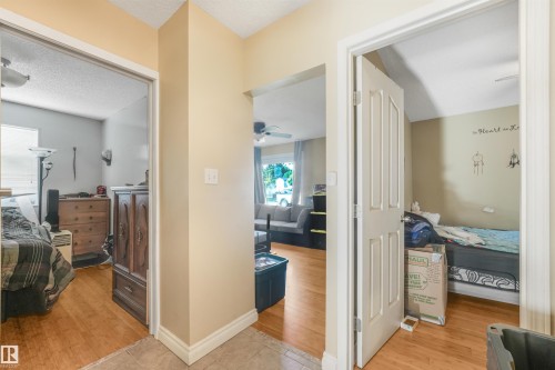 Wood-finish flooring throughout, with a tiled entry - 12209 94 Street Nw, Edmonton, AB - Indoor Photo Showing Bedroom