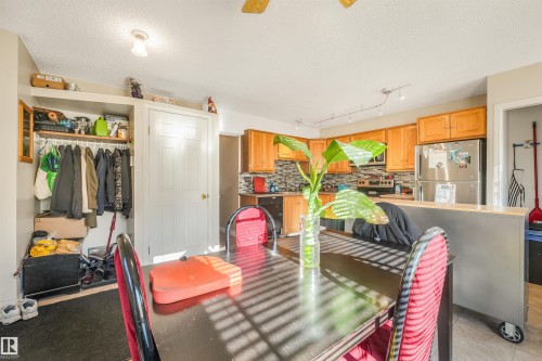 Kitchen with wood cabinetry, stainless steel appliances, and a tiled backsplash - 12209 94 Street Nw, Edmonton, AB - Indoor
