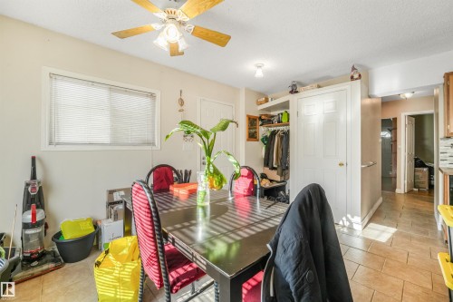 Ceiling fan with light fixture, window with blinds, built-in shelving, white paneled doors, and tiled flooring - 12209 94 Street Nw, Edmonton, AB - Indoor Photo Showing Dining Room