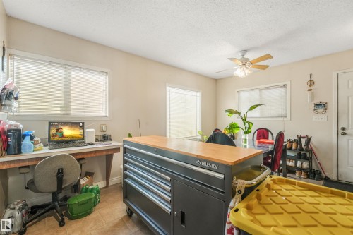Recessed windows with horizontal blinds, neutral wall paint, ceiling fan with light fixture, and tiled flooring - 12209 94 Street Nw, Edmonton, AB - Indoor Photo Showing Office