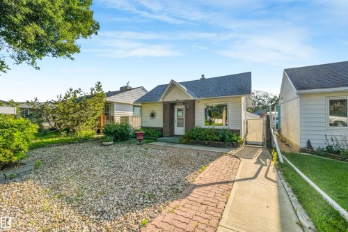 Traditional residence with a gabled roofline, brick-finish facade accents, and a paved walkway - 12209 94 Street Nw, Edmonton, AB - Outdoor