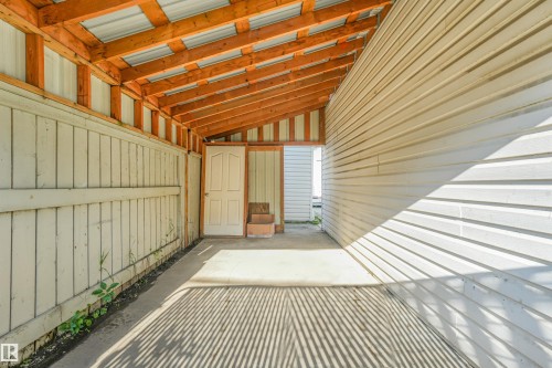 Covered concrete patio with exposed wood rafters and corrugated metal roofing - 12209 94 Street Nw, Edmonton, AB -  With Exterior